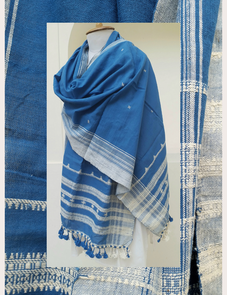 Blue and white patterned scarf on a mannequin with fabric swatches in the background