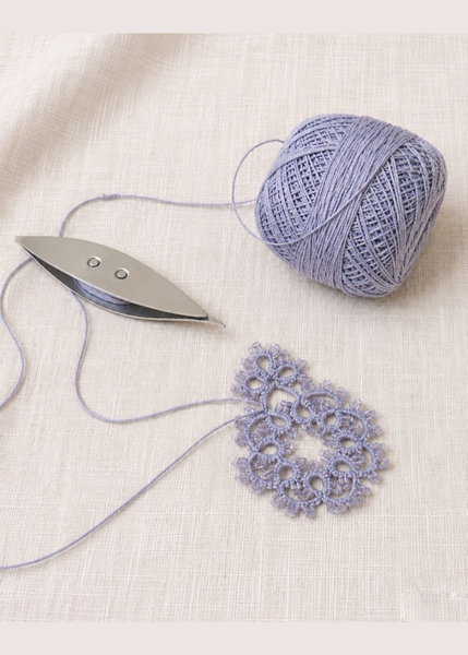 tatting demo with shuttle and ball of yarn
