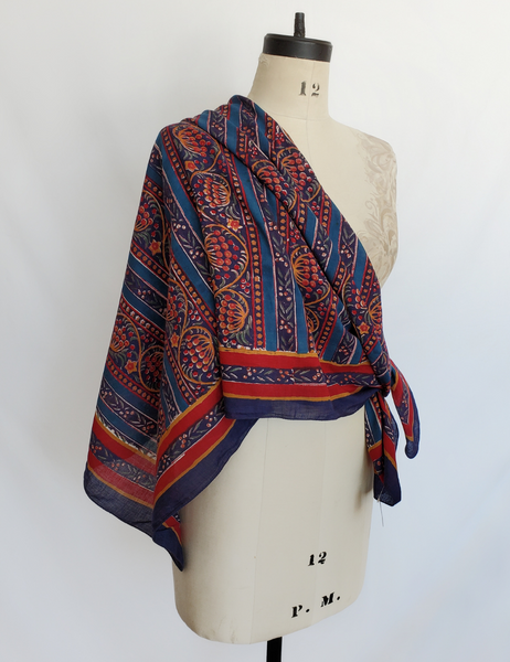 Red and blue detailed square scarf worn over one shoulder.