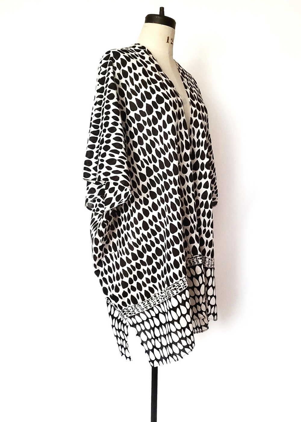 Playa kimono with two versions of butti print. White with black on top and at the waist it changes to black with white print. Short sleeves, slit on side.