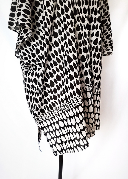 Playa kimono with two versions of butti print. White with black on top and at the waist it changes to black with white print. Short sleeves, slit on side.