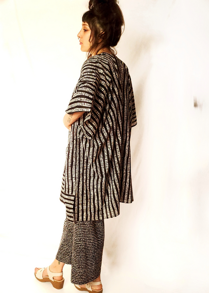 Playa kimono with two versions of butti print. White with black on top and at the waist it changes to black with white print. Short sleeves, slit on side.