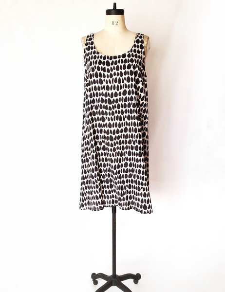 Mannequin wearing Gigi dress in butti print. 1-2 inch thick straps and sits near the knees.